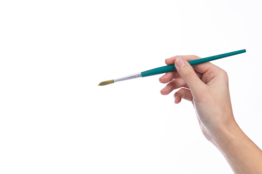 Art brush held in a lady's hand, on a white background
