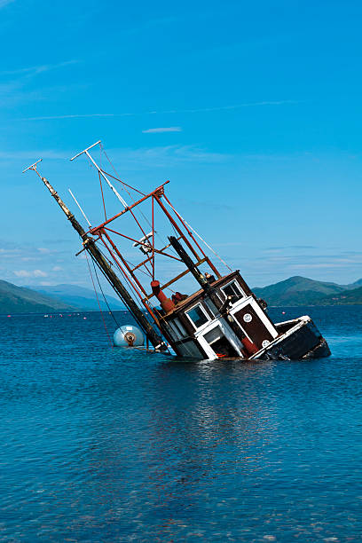 Boat, Partially submerged fishing vessel in Loch Linnie A foundered and partially submerged fishing vessel or samon farm support vessel in Loch Linnie just north of the village of Corran in Ardgour at  56 fishing boat sinking stock pictures, royalty-free photos & images