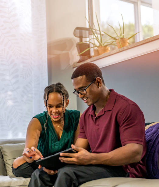 istock Two young people relax at home on the couch using digital tablet together 1362812923