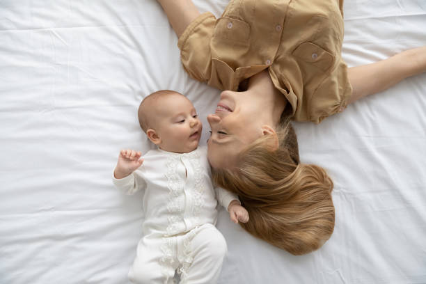 istock Top view loving young mother and baby lying on bed 1362814005