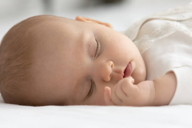 istock Close up cute newborn baby sleeping on cozy bed 1362814022