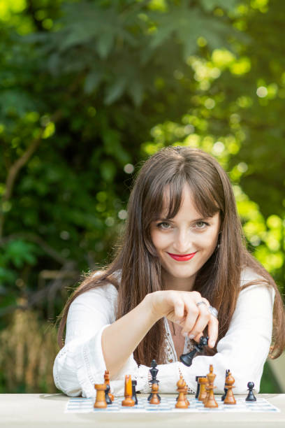 istock Young woman plays chess in a public park and makes her move with mischievousness 1362814461