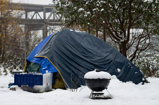 Portland, OR, USA - Dec 28, 2021: Homeless tent on the east bank of the Willamette River in Portland, Oregon, on a cold winter day after snowfall.