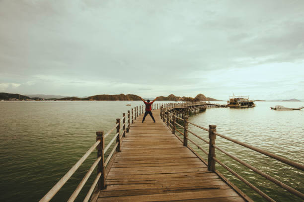 istock Back view of man walking on boardwalk 1362827878