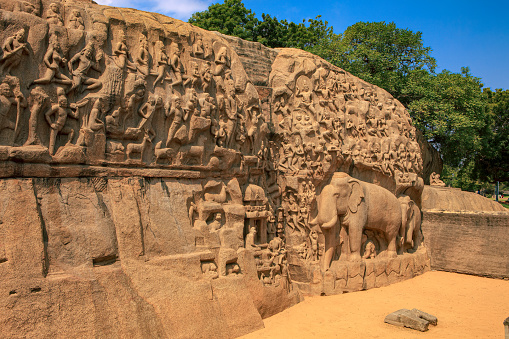 Descent of the Ganges, also known as Arjuna's penance, at Mahabalipuram or Mamallapuram, on the Coromandel Coast of the Bay of Bengal, in the Indian state of Tamil Nadu, India. Measuring 96 by 43 feet (29 m × 13 m), it is a giant open-air bas-relief carved out of two monolithic rocks. The legend depicted is the story of the descent of the sacred river, the Ganges from the heavens to earth, led by Bhagiratha. Centuries ago, they had water running between the two rocks; the bas-relief is sculpture at its best, and not seen anywhere else in India. It survived the Tsunamis of the 13th Century and 2004. It is one of the Group of Monuments at Mahabalipuram that were designated as a UNESCO World Heritage Site in 1984. Photo shot in the afternoon sunlight; horizontal format. No people.