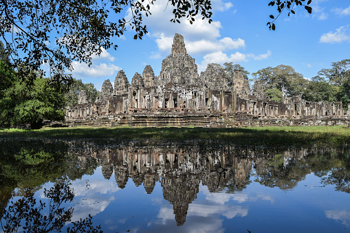 Majestic Bayon, a richly decorated Khmer temple at Angkor in Cambodia. Built in the late 12th or early 13th century as the state temple of the King Jayavarman VII, the Bayon stands at the centre of Jayavarman's capital, Angkor Thom.\nThe Bayon's most distinctive feature is the multitude of serene and smiling stone faces of The Buddha.