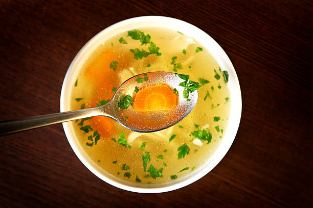 Traditional chicken soup A picture of a bowl of traditional chicken soup served in a bowl over wooden background chicken soup stock pictures, royalty-free photos & images
