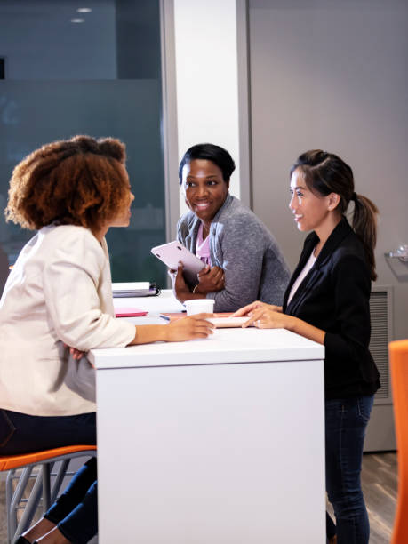 istock Three multiracial women talking in coworking break area 1362838982