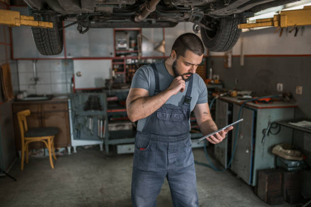 istock Worried car mechanic using digital tablet to search for car repair solutions 1362839773