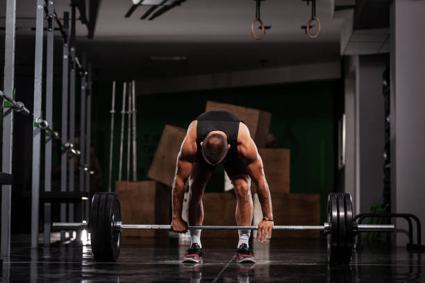 istock Muscular athlete lifting very heavy barbell 1362842397
