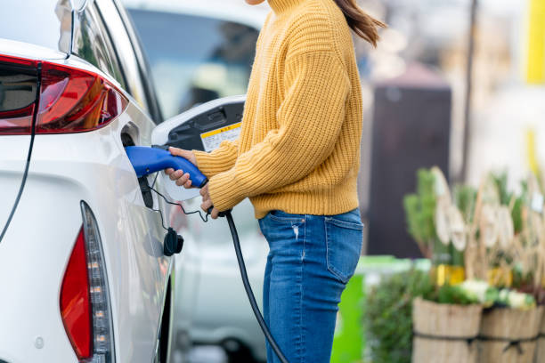 cierre enchufando el cargador de coche eléctrico - electric motor fotos fotografías e imágenes de stock