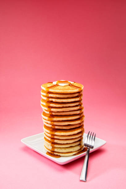 big tall stack of pancakes on pink background - plate food color image photography imagens e fotografias de stock