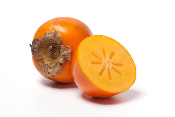 Photo of Ripe orange persimmon against white background