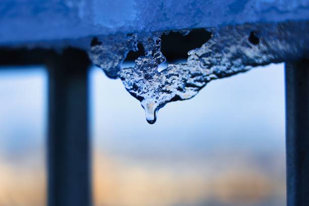 Icicles hanging from the railing and drips of thaw stock photo