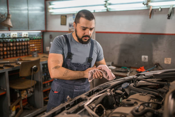 istock Young car mechanic examining engine in auto garage 1362845453