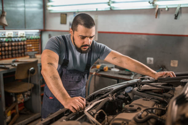 istock Worried young car mechanic examining engine in auto garage 1362846039