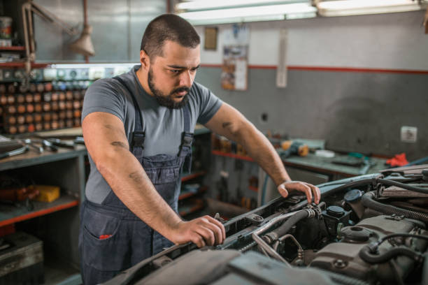 istock Tired mechanic is focused on examining engine in auto garage 1362846133