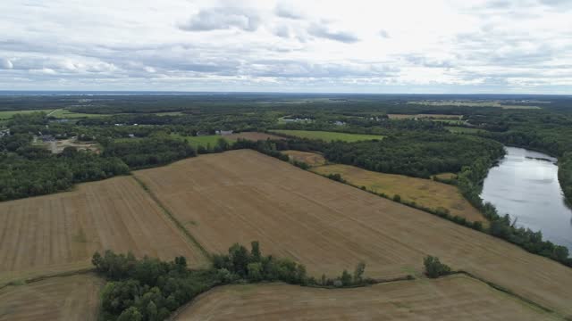 High aerial drone view, panning from left to right above an agricultural field in the country of Sainte-Genevieve-de-Batiscan