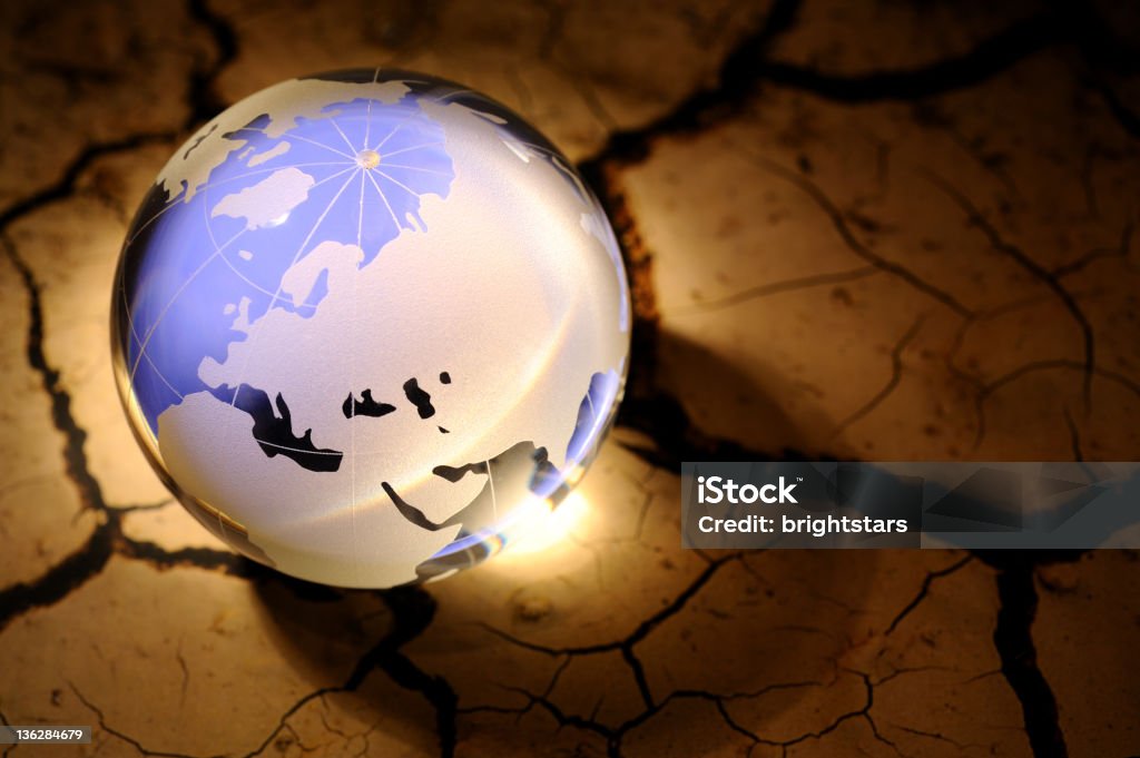 Blue globe on cracked dirt http://www.gunaymutlu.com/iStock/environment-360.jpg Arid Climate Stock Photo