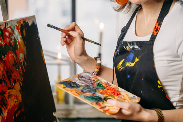 istock Woman artist creating canvas with paint in studio 1362858922