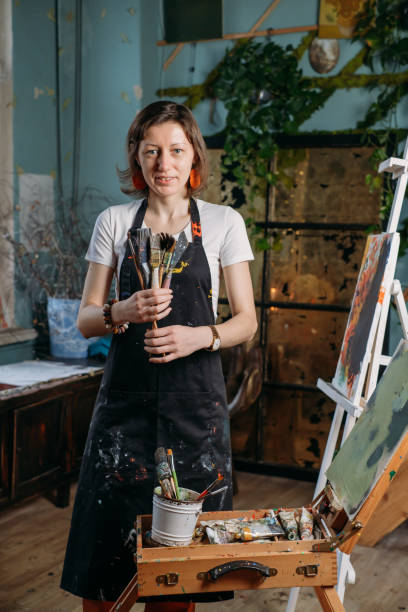 istock Woman artist creating canvas with paint in studio 1362858969
