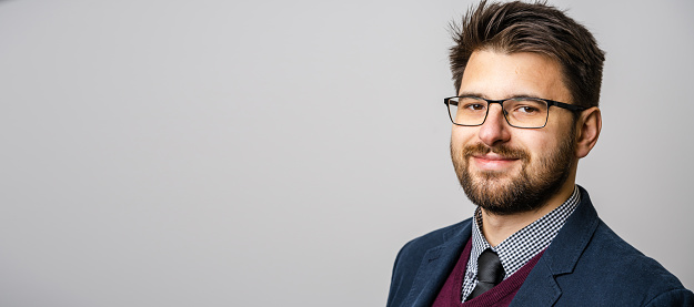 Happy, pride and portrait of businessman in office with positive, good and confident attitude. Smile, law career and face of professional male attorney in a suit standing in modern workplace.