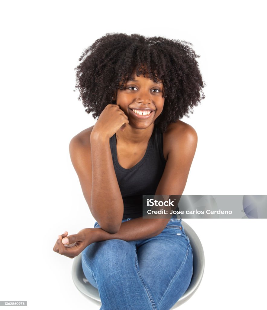 pretty afro american woman sitting on a chair posing white background One Woman Only Stock Photo