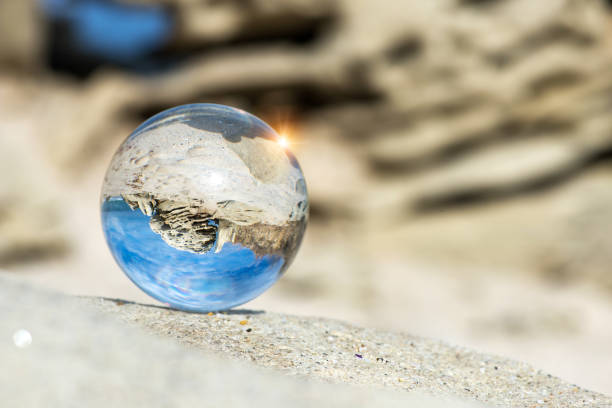 istock Upside down seascape with blue sky and rocks - reflection in a lens ball - selective focus, space for text 1362861873