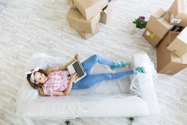 istock Young woman with dog lying on sofa using laptop 1362861934