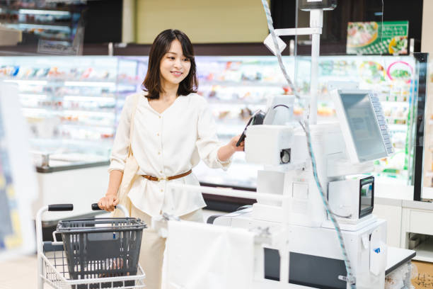 istock Young woman using smartphone payment at a supermarket 1362864538