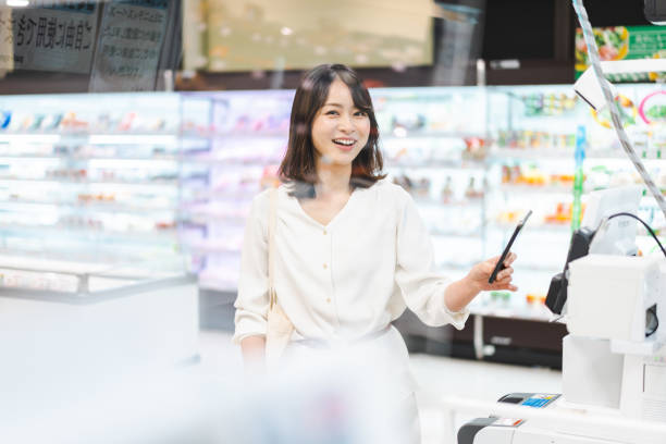 istock Young woman using smartphone payment at a supermarket 1362864554