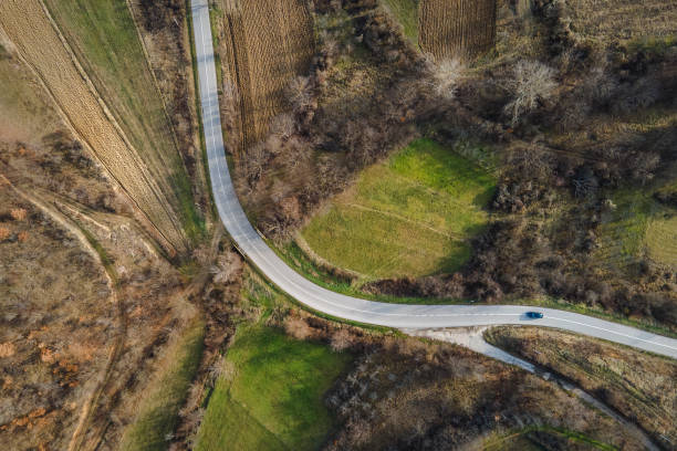 istock Aerial view top down from above on the country road in mountain range in between fields grass and trees around - nature travel concept drone photo on Stara Planina Old Mountain in Europe Serbia 1362866439