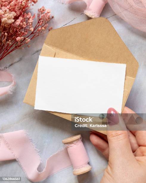 Hand With Card And Envelope With Pink Flowers And Ribbons Stock Photo - Download Image Now