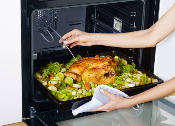 istock Woman checking thanksgiving turkey in oven 1362869178