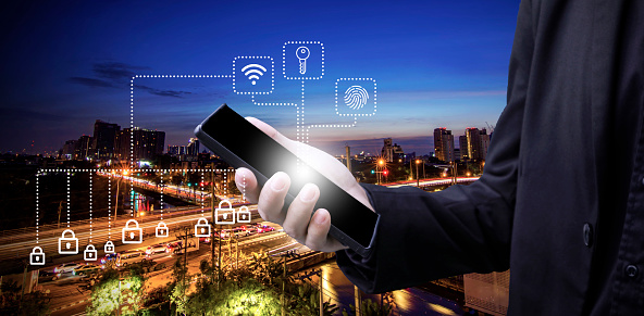 Business man hold smartphone in hand with icon symbol screen in concept of network connect control and security with city twilight sunset sky long exposure light background landscape
