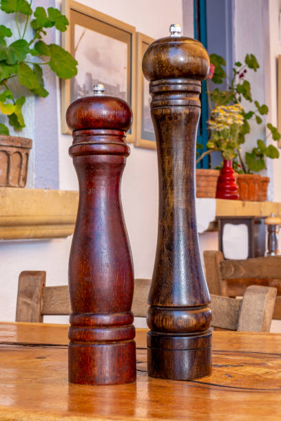 Wooden pepper and salt mill on a table in a restaurant Wooden pepper and salt mill on a table in a restaurant salt pepper ingredient black peppercorn stock pictures, royalty-free photos & images