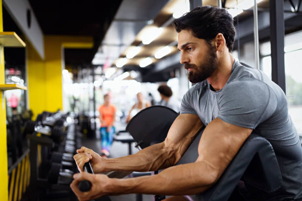 istock Muscular bodybuilder handsome man doing exercises in gym. Sport people workout concept 1362872918