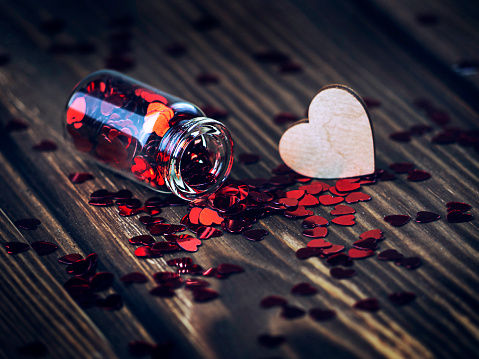 Glass jar with Hearts on Wooden Background, and the Word Love Concept, Valentine's Day