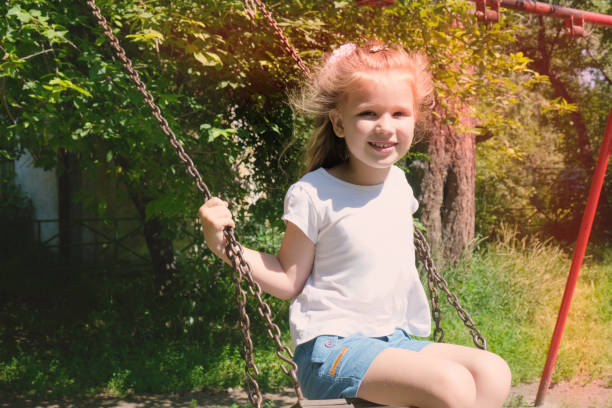 スイング、夏の時間に幸せな子供の女の子。ライフイベント。 レトロ調、ソフトフォーカス効果 - swing child swinging front or back yard ストックフォトと画像