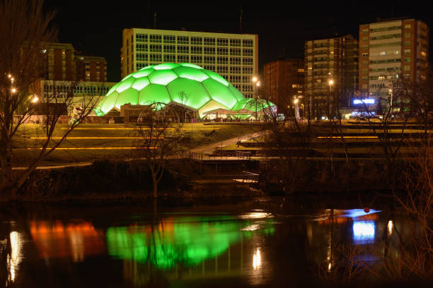 Valladolid, Valladolid,España- Febrero 27, 2016; Reflections of city lights on a river with a dome in the shape of a hemisphere illuminated in green.