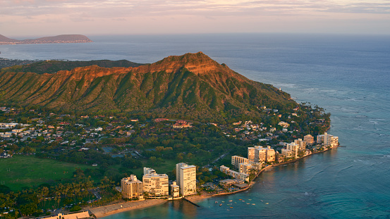 Aerial view of Diamond head mountain with modern buildings at sunset, Honolulu, Hawaii Islands, Oahu, USA.