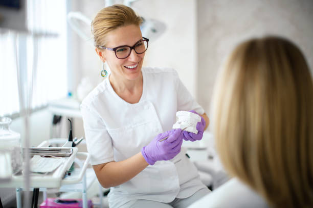 Dentist showing dental plaster mold to the patient. stock photo