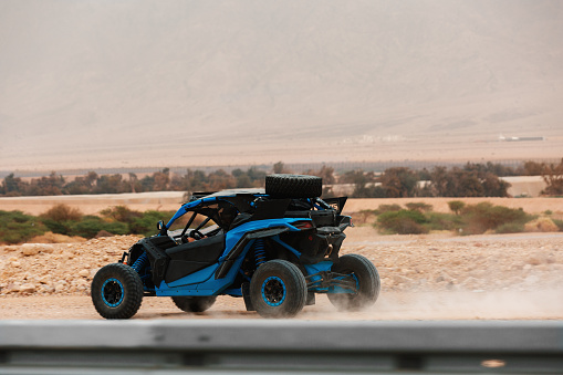 Side view of buggy car driving in the desert