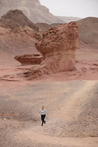 istock Woman walking between desert canyons and rocky formations 1362882399