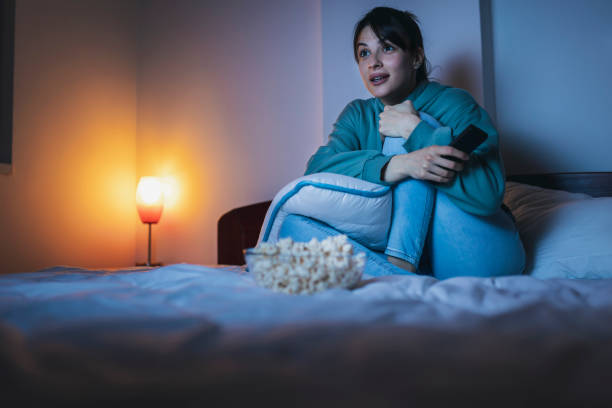 istock Woman watching TV in bed at night 1362883458