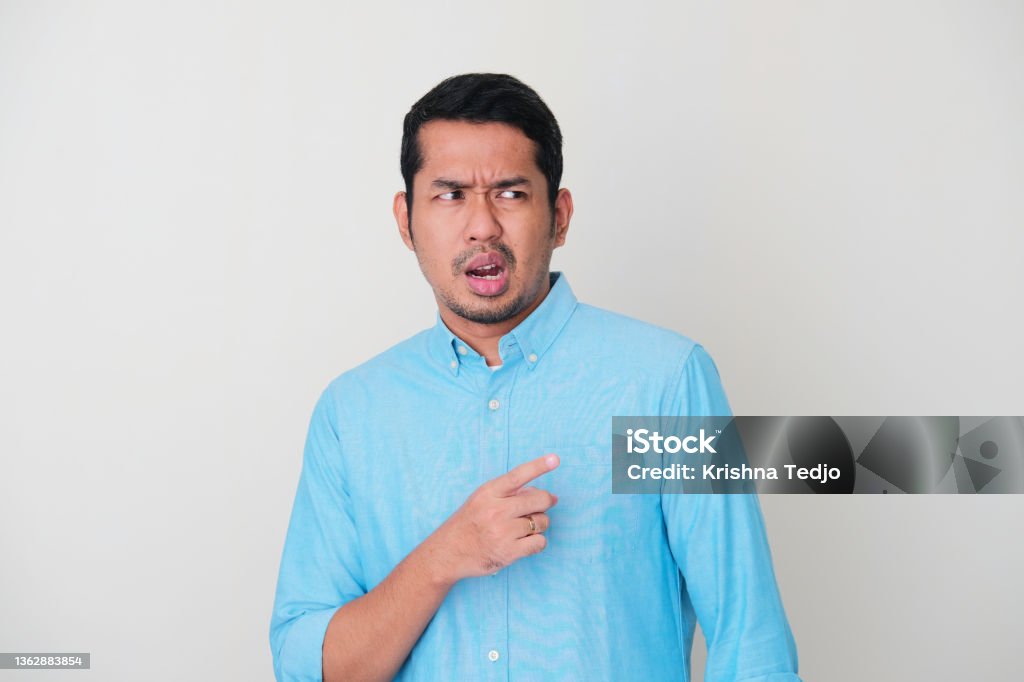 Adult Asian man showing not happy expression when looking and pointing someone 35-39 Years Stock Photo