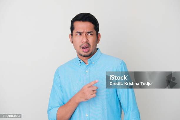 Adult Asian Man Showing Not Happy Expression When Looking And Pointing Someone Stock Photo - Download Image Now