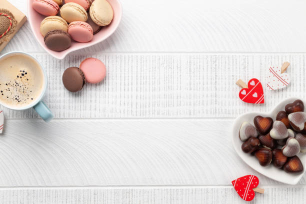 Homemade macaroons, heart chocolate and coffee cup. Top view flat lay with copy space. Valentines day