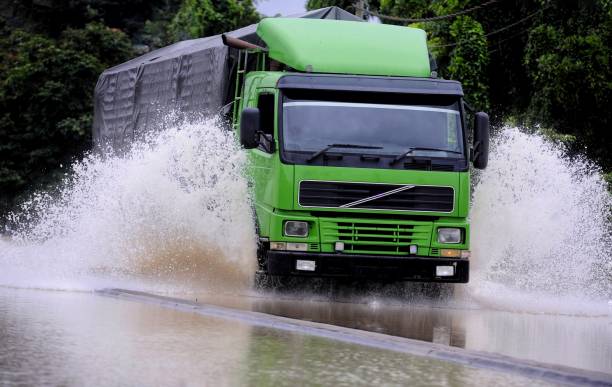 Objects and transportation Heavy vehicles wade through the floodwaters truck in rain stock pictures, royalty-free photos & images