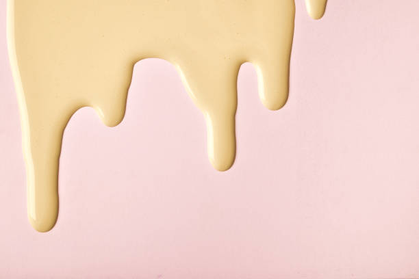 istock Golden liquid drops of paint color flow down pink background. Abstract backdrop 1362885848